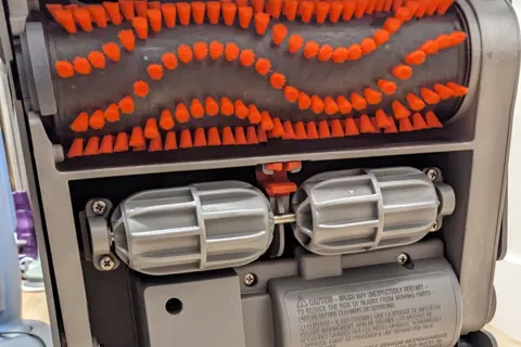 Underside of the machine with the grey suction slot above the brush